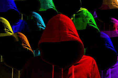 Group of differently colored hooded hackers with side light diversity cybersecurity conceptの写真素材