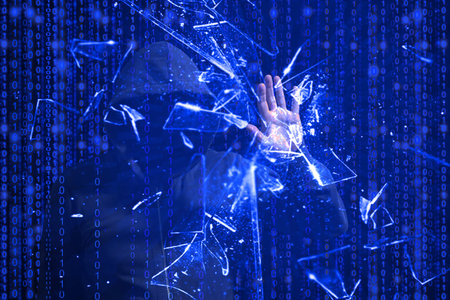 Hooded hacker smashing the screen with one hand in front of blue binary background cybersecurity...