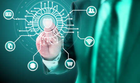 Businessman clicking on the center of a circuit panel with a shield connected to IOT iconsの写真素材