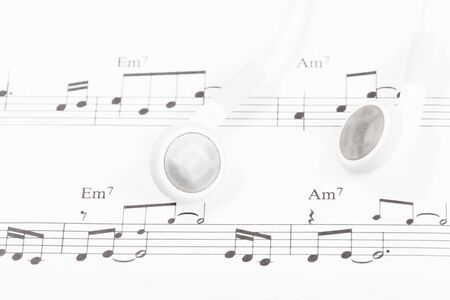 White earphones on a music noteの写真素材