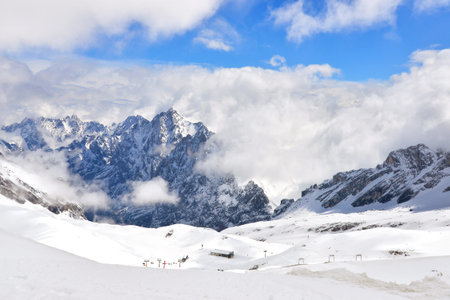 Clouds & snow on Zugspitze with view of ski area