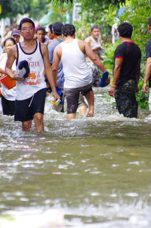 BANGKOK - OCT 29: Unidentified residents of Bangkok's Dusit district make their way through flooded streets after the Chao Phraya River bursts its banks on Oct 29, 2011 in Bangkok, Thailand.のeditorial素材