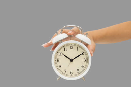 Hands holding alarm clock on green bacground.の写真素材
