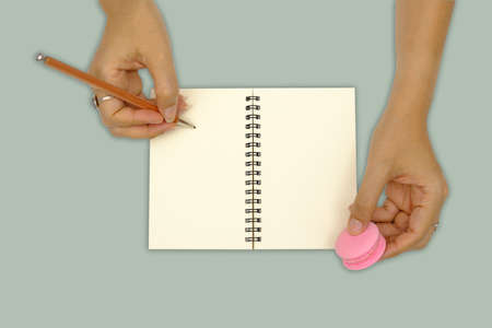Hands are writing on the book isolated on green background.の写真素材