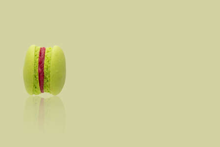 A green macaroon on the yellow background.の写真素材