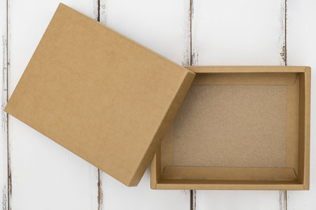 Opened cardboard box on a white wooden table