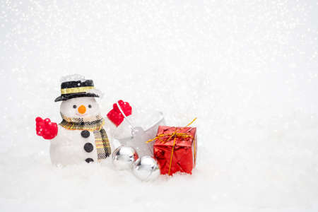 Snowman with gift box is standing in snowfall, Merry Christmas and happy New Year concept.の写真素材