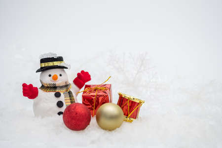 Snowman with gift box is standing in snowfall, Merry Christmas and happy New Year concept.の写真素材