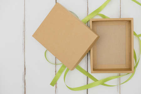 Opened cardboard box on a white wooden tableの写真素材