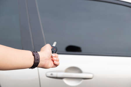 Hand presses on the remote control of golden car.の写真素材