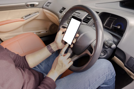 Hand is holding a touch phone with isolated screen in the car.