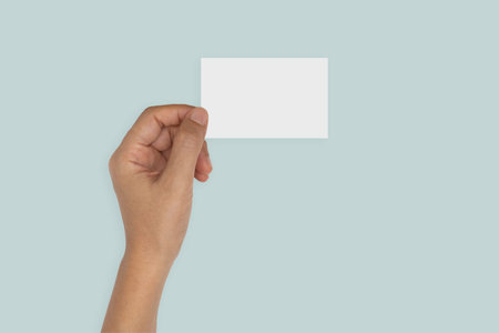 hand holding blank card isolated on blue background.