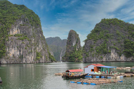 A floating fishing village in between the thousand islands of Halong Bay in Vietnamの写真素材