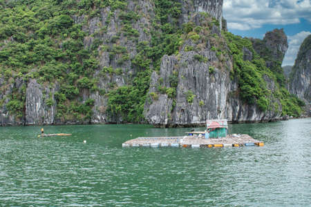 A floating fishing village in between the thousand islands of Halong Bay in Vietnamの写真素材