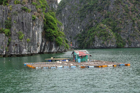 A floating fishing village in between the thousand islands of Halong Bay in Vietnamの写真素材