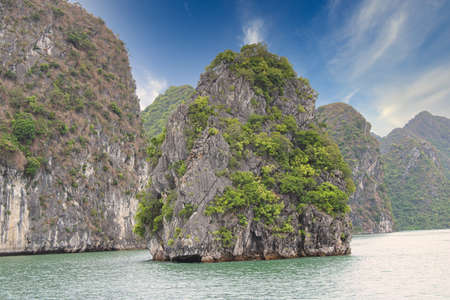 Isolated island in the middle of world famous nature heritage Halong Bay in Vietnamの写真素材