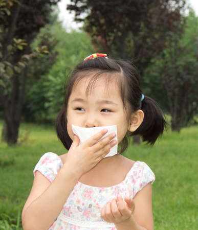 Asian little girl wipe your mouth with a tissueの写真素材