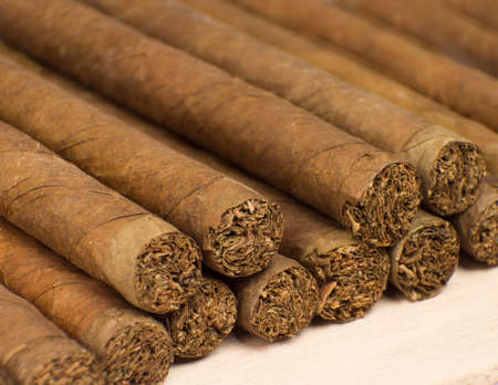 Heap of cigars on old wooden surface.の写真素材