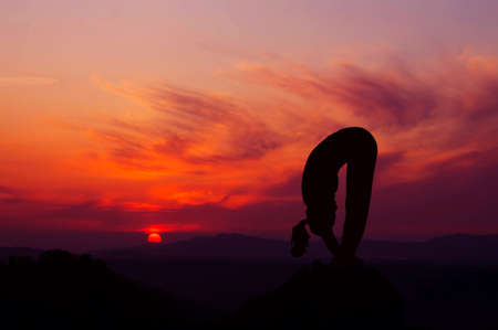 Silhouette of a beautiful Yoga woman in the morningの素材 [FY31016331575]