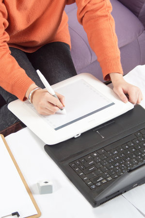 Graphic designer working in office using tablet penã€‚