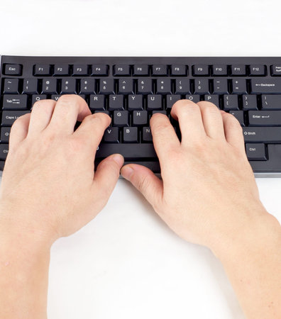 Closeup of hands typing on a keyboard.