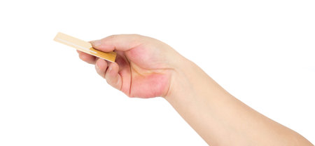 Businessman's hand in a golden holding blank paper business card, closeup isolated over white...