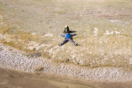 Hiker resting on the grass in autumn sunlightの写真素材