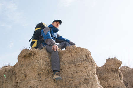 Sitting on a cliff resting hikers. Asian Youthの写真素材