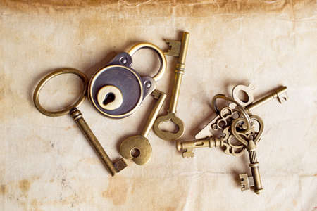 Retro copper keys and padlock on vintage paper backgroundの写真素材