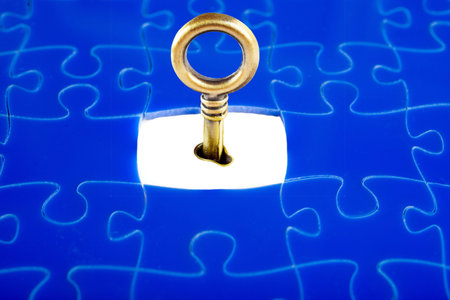 Jigsaw Puzzle with the missing piece, with a key to openの写真素材