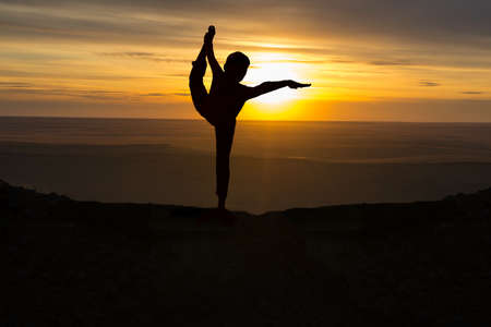 Girl practicing yoga at sunrise, outdoor sunの写真素材