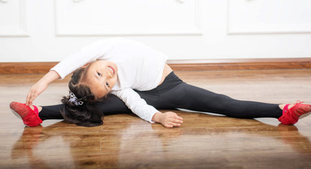  little girl doing sports exercises on the mat  の写真素材
