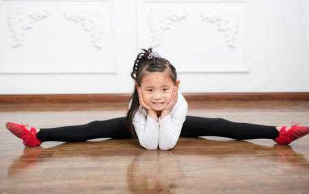 Studio image of a cheerful emotional little girl in a beautiful  is dancingの写真素材
