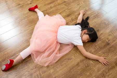 Wear shoes little girl sleeping on the wooden floorの写真素材