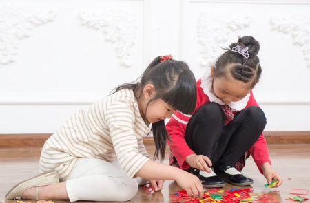 Two little girls play games in the indoor floorの写真素材