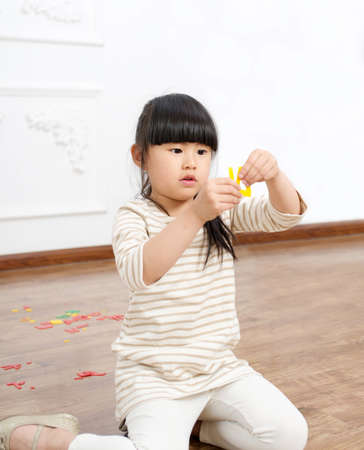 The little girl to play games, in the indoor floorの写真素材