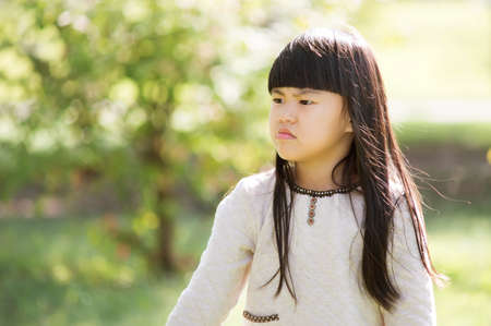 The angry girl in outdoor park. Pouting.の写真素材