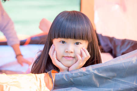 The little girl lying indoor of camping tent smilingの写真素材