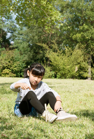 The small beautiful girl on a green lawnの写真素材