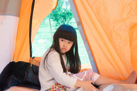 The little girl lying indoor of camping tent smilingの写真素材