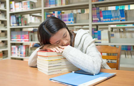 The fatigue of the female students. Sleeping in the libraryの写真素材