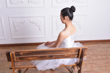 Female ballet dancer sitting on a bench to restの写真素材