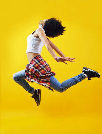 Beautiful young hip-hop dancer, jumping in the airの写真素材