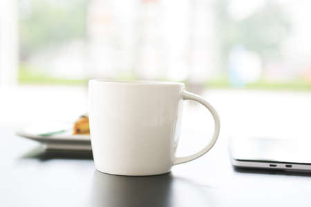 Tablets and close-ups of coffee cup on the tableの写真素材