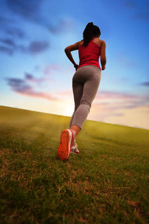 Girl running in the park on the grassの写真素材