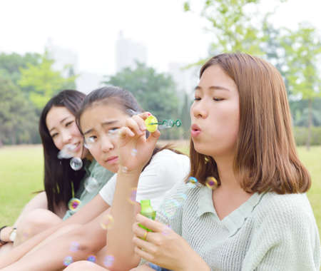 Three female students playing with bubblesの写真素材
