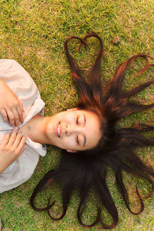 Fashion girl lying on the lawnの写真素材