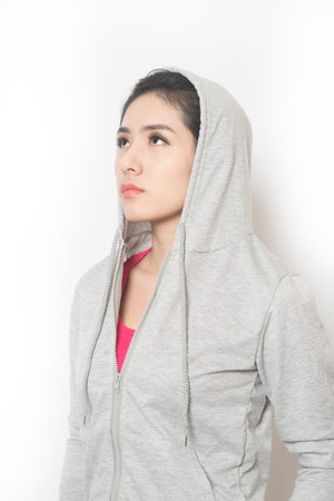 Confident woman in sportswear posing for camera against white background.