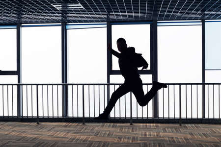 Men are jumping in the office corridor.Silhouetteの写真素材