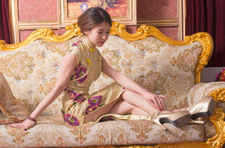 chinese girl wearing cheongsam sitting on the sofa.のeditorial素材
